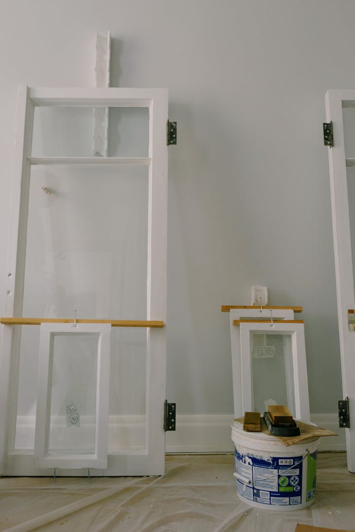 A stylish home renovation scene featuring window frames and paint supplies inside.